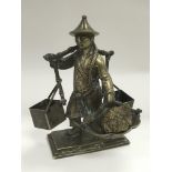 A brass figure of a Chinese miner in traditional c