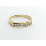 A Gold ring set with a row of brilliant cut diamon