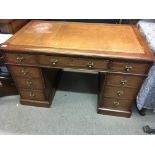 A late Victorian oak pedestal desk with a leather