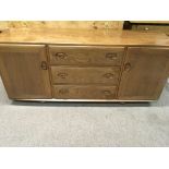 A Ercol sideboard fitted with three drawers flanke
