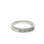 An unmarked white gold half eternity emerald and d