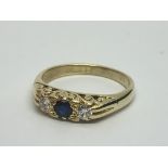 An 18ct gold ring set with a central sapphire and