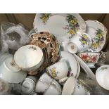 A box containing decorative tea sets and other cer