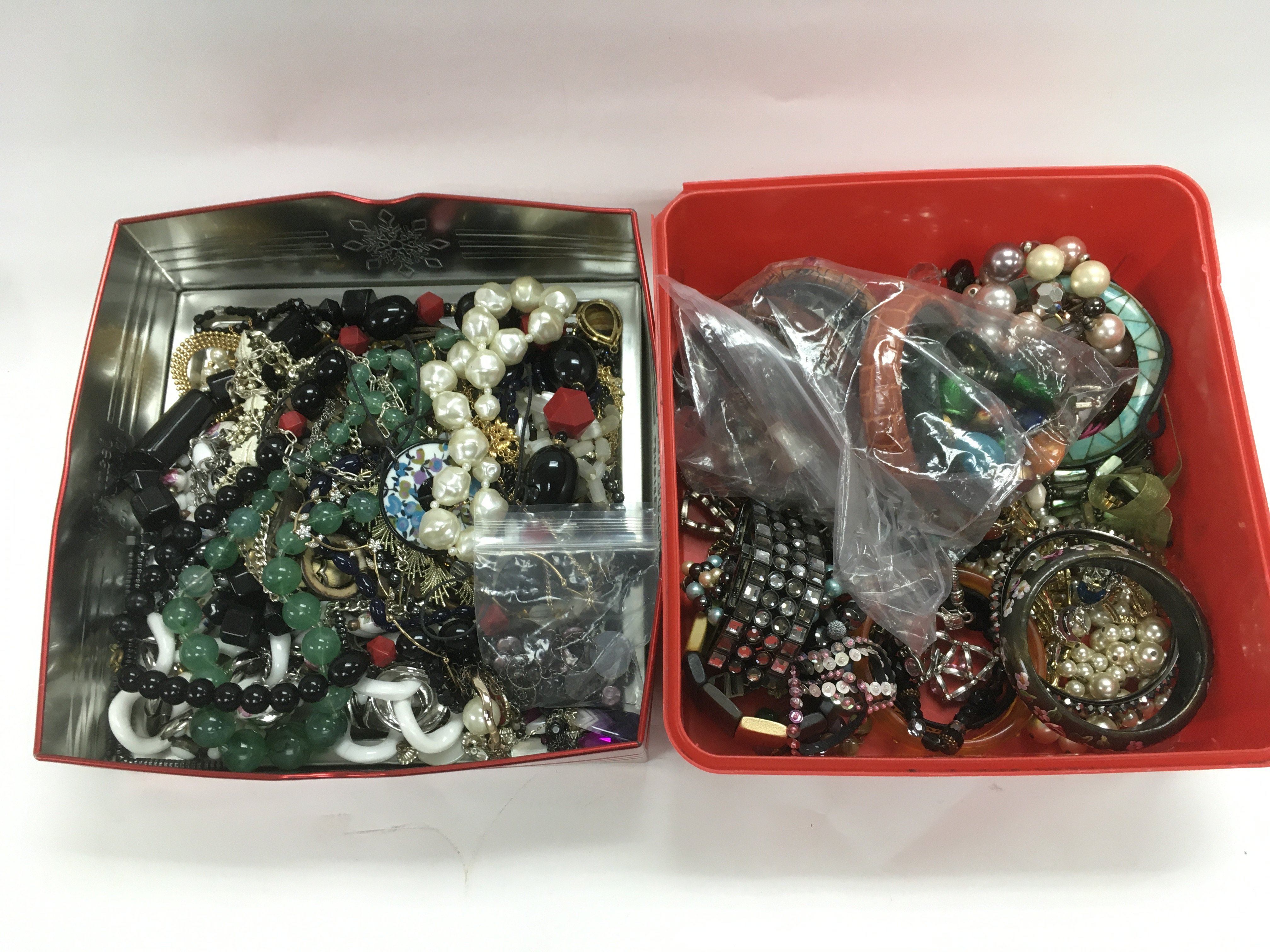 Two tins of costume jewellery.