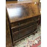 A walnut bureau with a fall front above four drawe