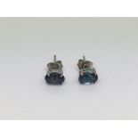A pair of silver studs set with London blue topaz