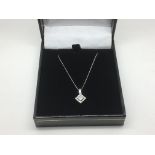 An 18ct white gold diamond set pendant on a white