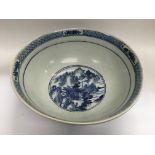 A large 19th Century blue and white bowl with landscape scenes to the exterior and interior,