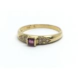 An 18ct yellow gold ring with central ruby surrounded by smaller diamonds, ring size approx N