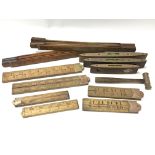 A collection of tools and measures consisting of eight wood and brass rulers, three spirit levels