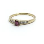 A 14ct yellow gold ring, the central ruby flanked by six diamonds, ring size approx N/O