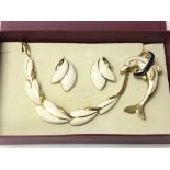 A Trifari gold tone jewellery set consisting of a necklace and earrings decorated with cream