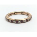 An 18ct rose gold eternity ring surrounded by alternating rubies and diamonds, ring size approx M