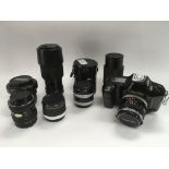 A collection of various Canon camera lenses, a Canon T90 camera and accessories.