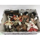 A box of antique Japanese dolls with silk clothing.