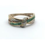 A 9ct yellow gold crossover ring having rows of emeralds and diamonds, ring size approx R