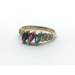 A 14ct yellow gold multi stone ring, the central sapphire, ruby and emerald flanked by six diamonds,