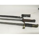 An Antique bayonet with brass cross fitting a d two other bayonets no scabbards.