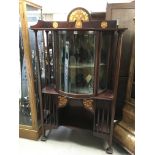 A mahogany inland display cabinet with Art Nouveau influences the raised back above a bow fronted