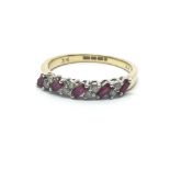 An 18ct yellow gold half eternity ring having five baguette cut rubies and eight small diamonds,