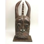 A large wooden tribal mask inset with glass trader