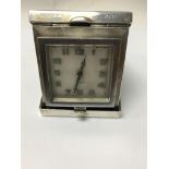 A 8 day silver case travel clock the square dial w