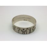 An Irish silver bangle decorated with various symbols, approx 50g.