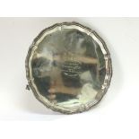 A silver circular tray with a scalloped edge, Sheffield hallmarks, approx diameter 20.5cm and approx