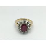 An 18ct gold ruby and diamond cluster ring set with a central oval cut ruby, approx 2.50ct, RBC