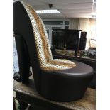 A Novelty chair in the form of a High heel shoe With leopard print.