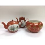 Two Oriental teapots of matching decoration on an orange ground plus a Chinese vase decorated with a