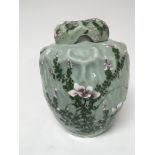 A Chinese celadon jar and cover with an internal lid the sides decorated with flowers and foliage