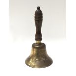 An old brass hand bell with wooden handle