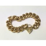 A chunky gold plated chain link bracelet with heart shaped clasp