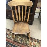 A elm rocking chair the slate back above a solid seat on turned legs