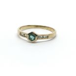 A 14ct yellow gold ring, the central emerald flanked by six diamonds, ring size approx M
