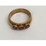 A 18 ct gold ring inset with three rubies size k