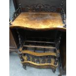A walnut Victorian Canterbury the serpentine top above three open sections with a single drawer on