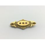 A 15ct gold brooch set with a small diamond and two rubies, approx 4.4g.