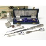 A collection of small silver items including button hooks, spoons, vesta case and a scent bottle, in