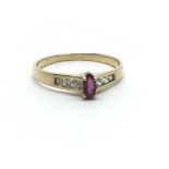 A 14ct yellow gold ring the central ruby flanked by six diamonds, ring size approx N/O