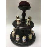 A collection of royal crown derby thimbles on stand .