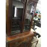 A Victorian mahogany bookcase cupboard fitted with two drawers and cupboards under on a plinth