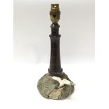 An old serpentine marble lamp in the form of a lighthouse on rock with die cast seagull