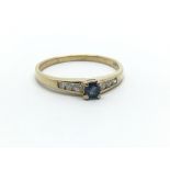 A 14ct ring, the central sapphire flanked by six small diamonds, ring size approx N/O