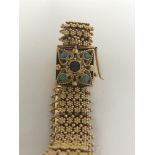 A continental gold bracelet marked 800 the floral design strap with clasp inset with turquoise