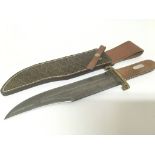 A large Bowie Knife with a walnut grip brass cross piece and quality Damascus steel blade.