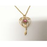 A 20carat gold pendent set with a Pink Tourmaline with open scrolls and an 18carat gold chain
