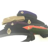 A collection of Military Essex Regimental cloth caps with applied badges.