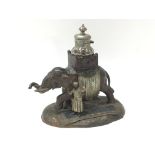 A vintage metal elephant sculpture with glass inkwell